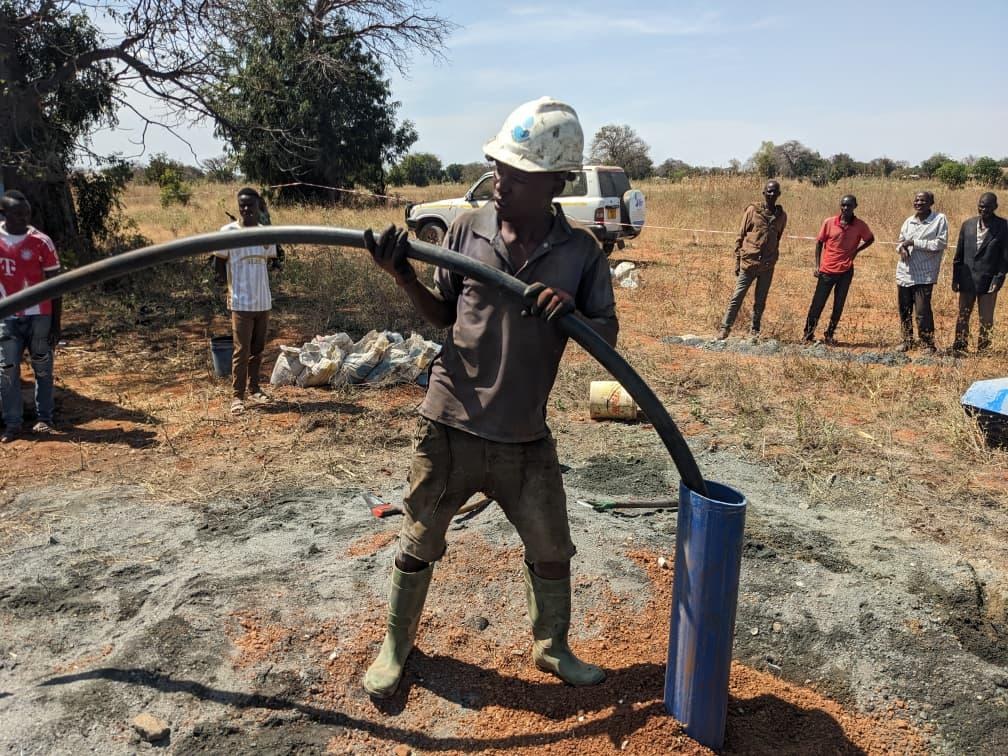 A community member operating a water pump